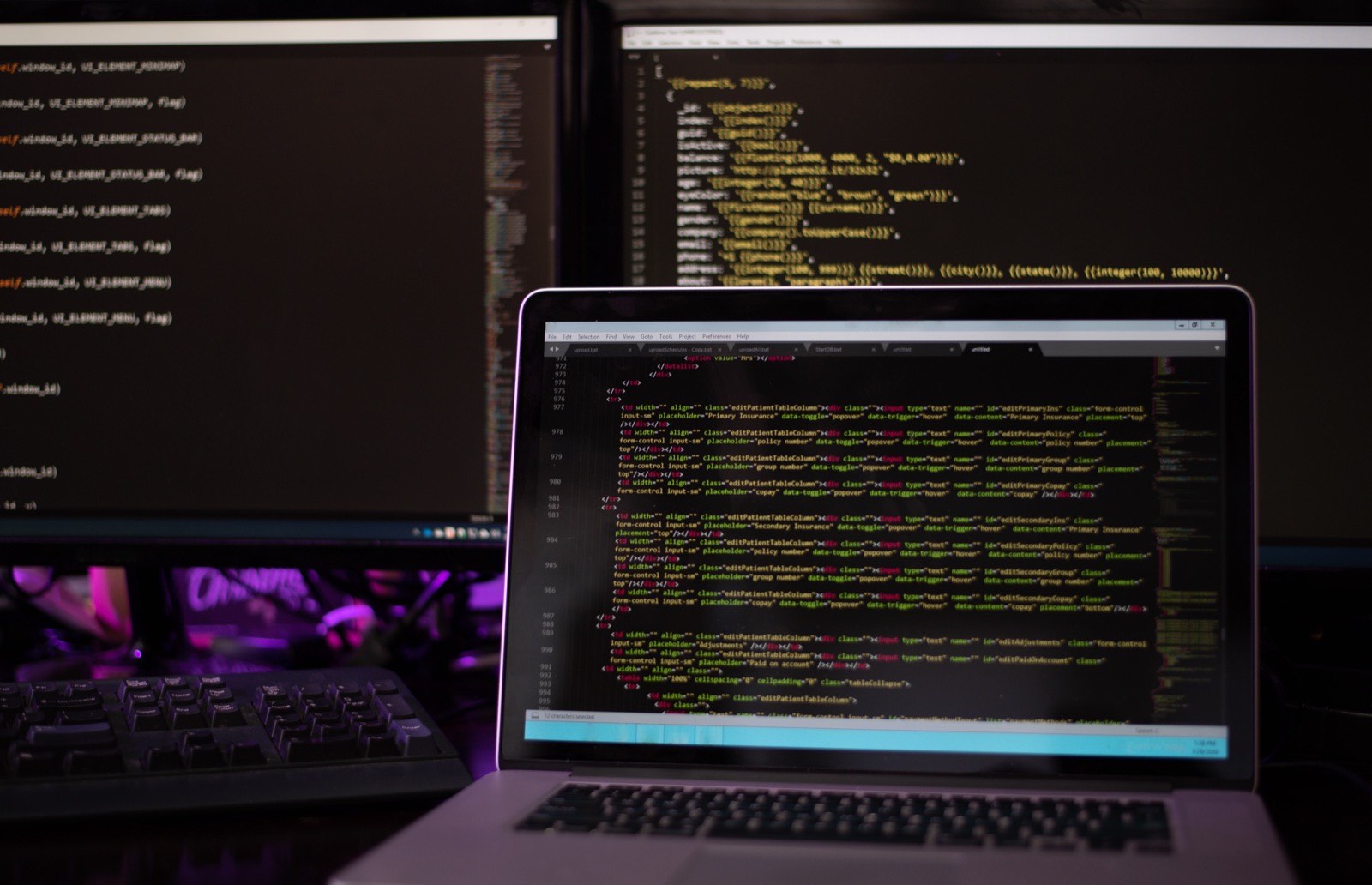 Trois écrans affichant du code