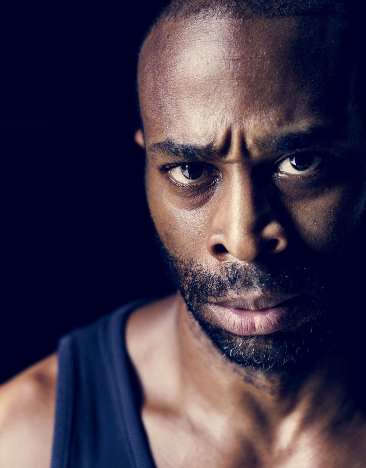 Homme au regard déterminé dans la pénombre
